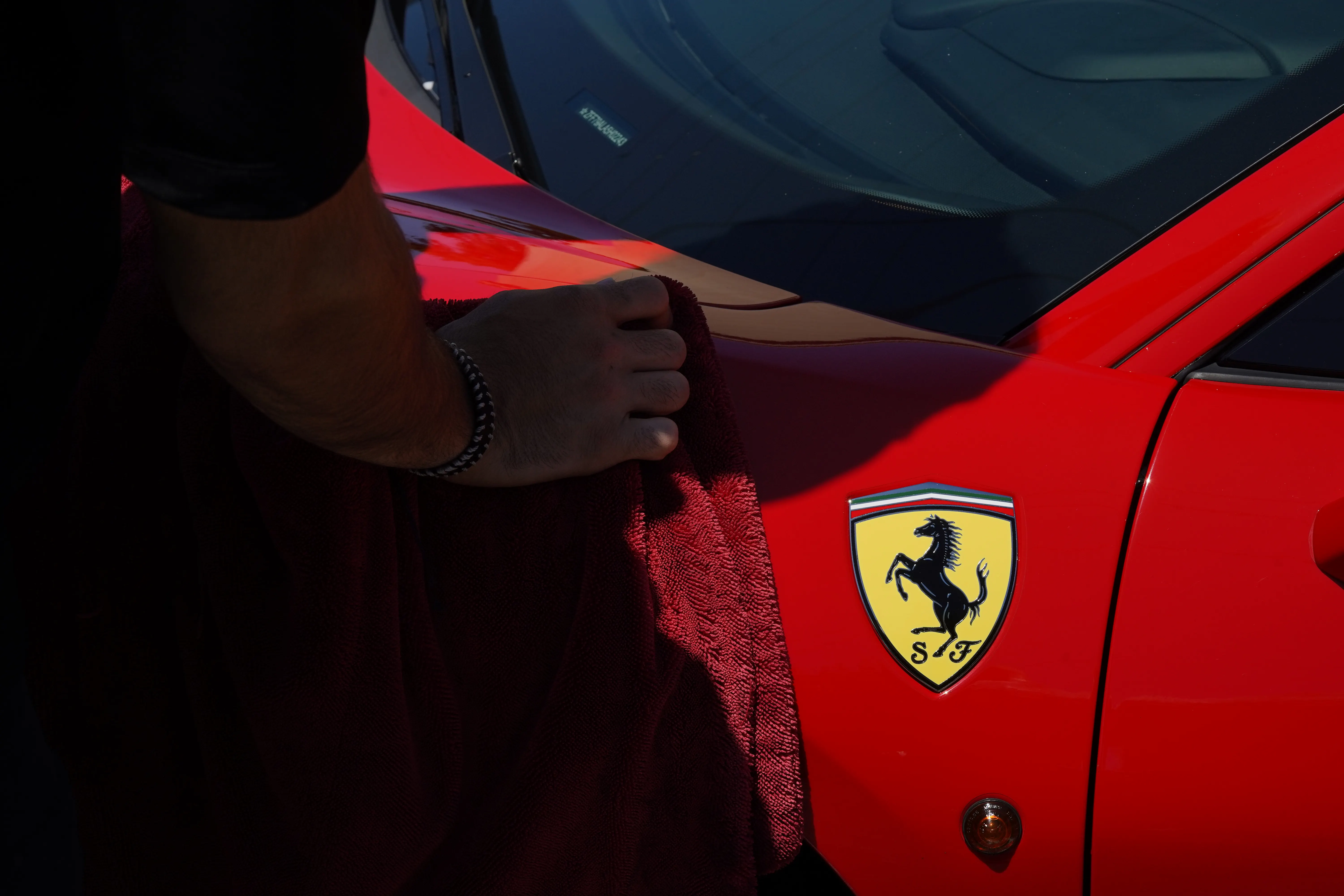 Hand-finishing the fender of a red Ferrari 488