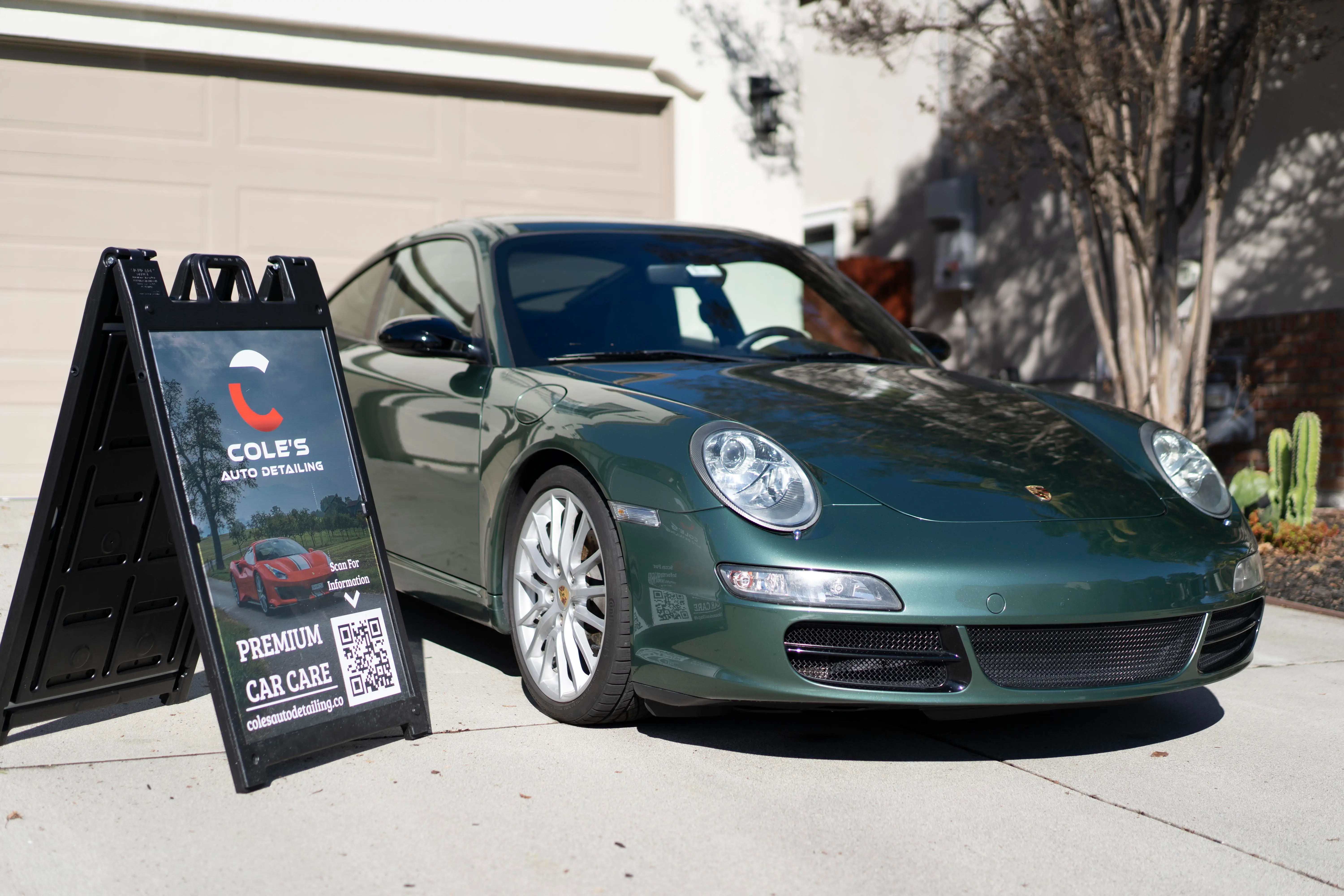 Green Porsche 911 beside the Cole’s Auto Detailing sign