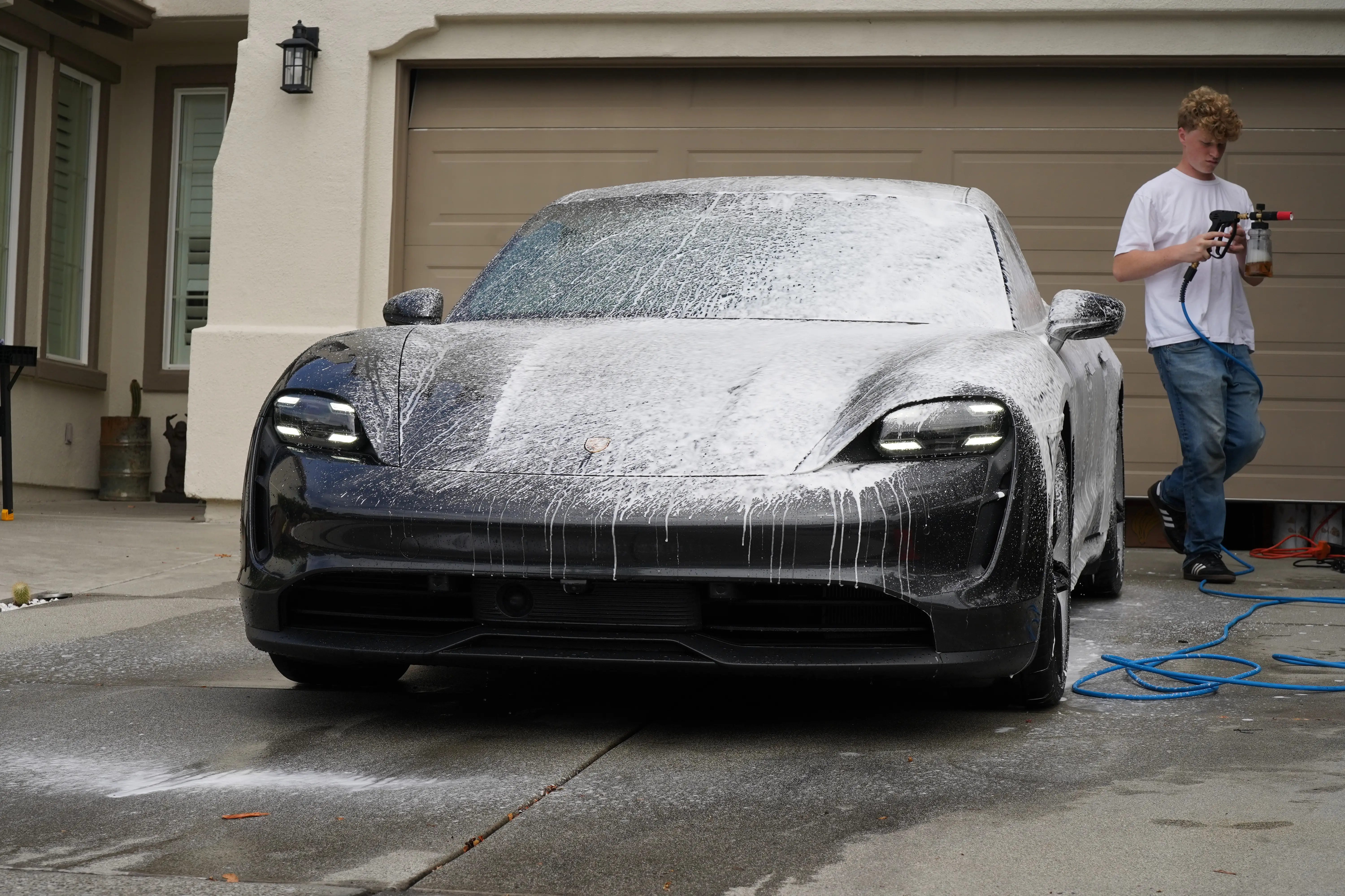 Porsche Taycan covered in foam during a maintenance wash