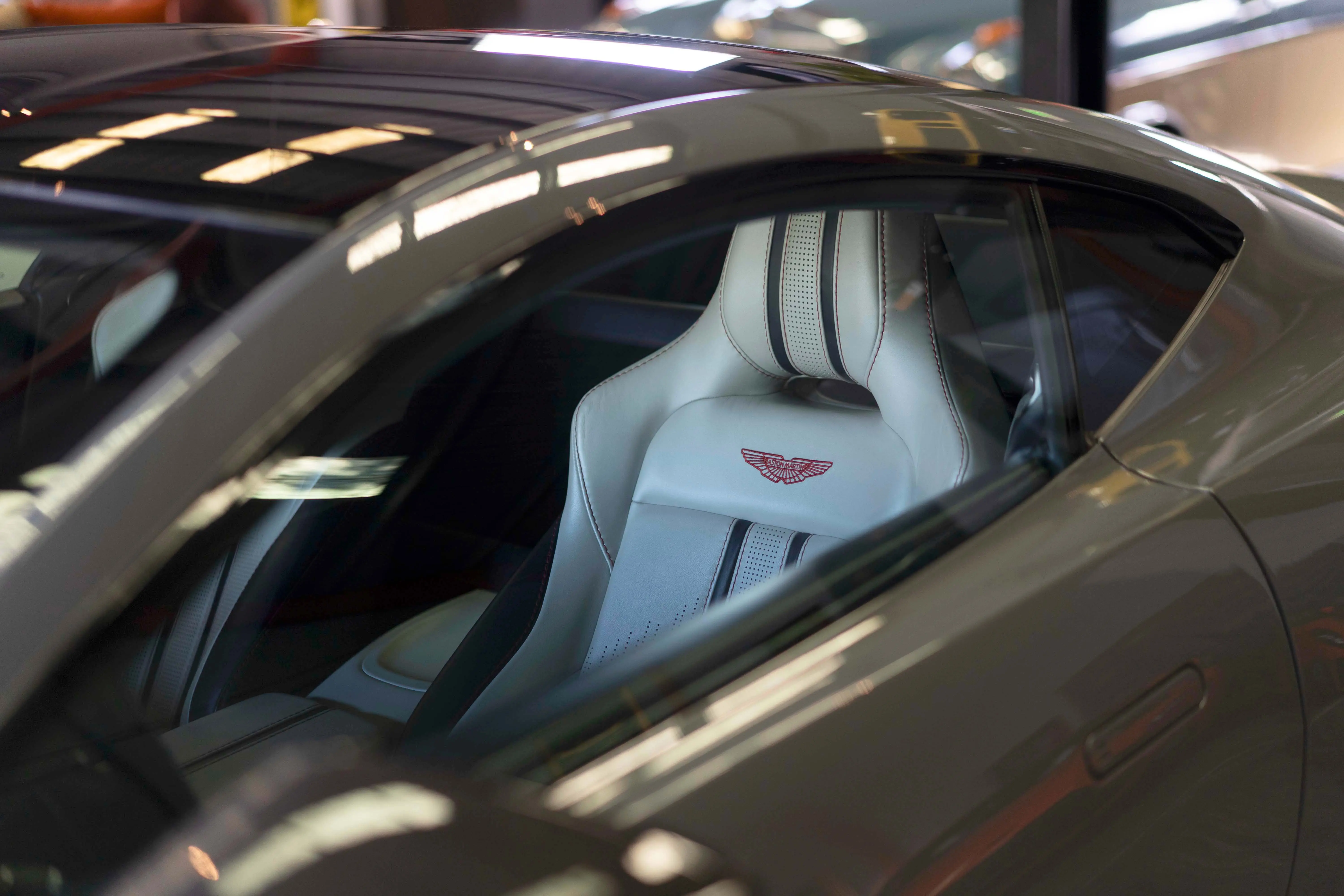 Aston Martin seat with red-stitched wings, cleaned and conditioned